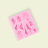 A pink silicone mold with various seashell shapes for food decoration.
